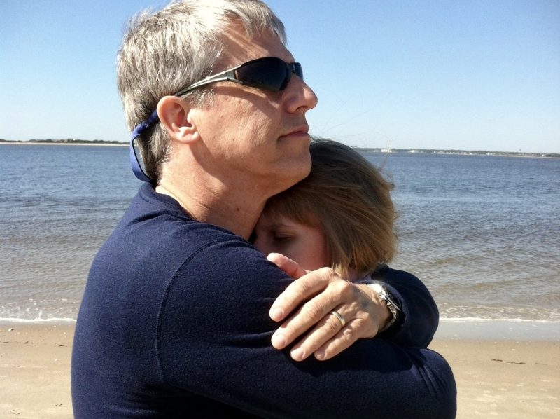 grieving father | Batten Disease News | Jim King hugs his daughter Taylor on the beach.